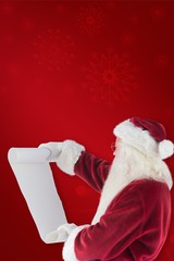 Composite image of santa claus reads a list