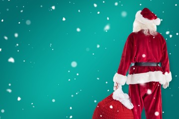 Composite image of santa carrying sack of gifts
