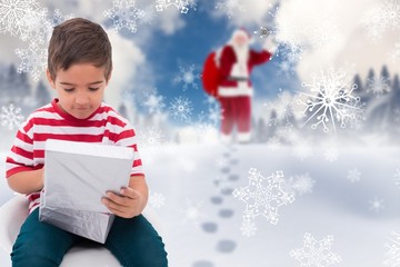 Composite image of cute little boy opening gift