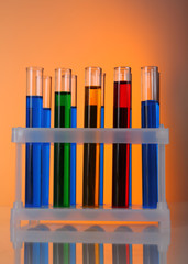 Test-tubes in container with colorful fluid on bright