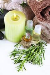 Branches of rosemary and sea salt, towels, candle and bottle