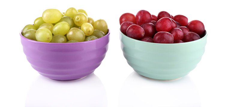 Two bowls of green and red grapes isolated on white