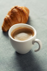 Breakfast concept: cup of coffee and croissant