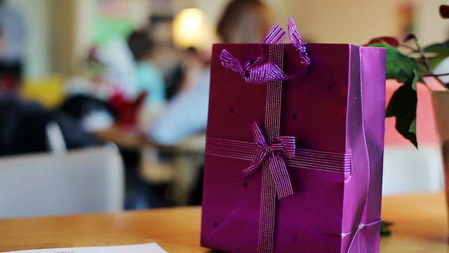 Wrapped gift, present on table in cafe