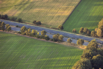 Aerial view of empty highway between fields