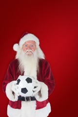 Composite image of santa holds a classic football