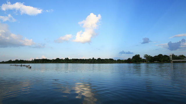 Lake with blue sky and clouds reflected in water.