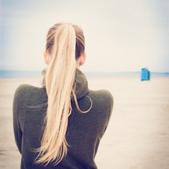 Lonely blond girl on foggy beach