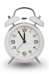 White alarm clock with hands at 5 minutes till 12