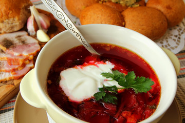 A plate of hot borscht with sour cream.