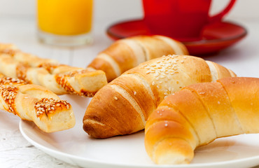 Fresh croissants and rolls with coffee and orange juice