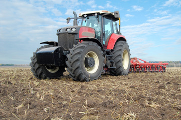 Obraz premium Tractor makes tillage