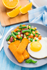 Fish sticks, fried egg and vegetables