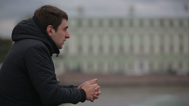 Sad man standing on the bridge in the center of St. Petersburg