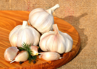 Organic garlic in a wooden bowl on the cutting board