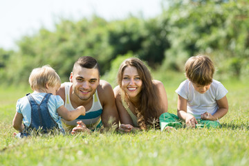 Fototapeta na wymiar Family of four in grass at park