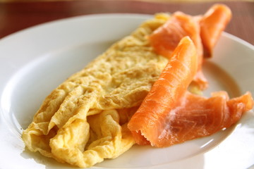 Salmon slices and French omelette on plate
