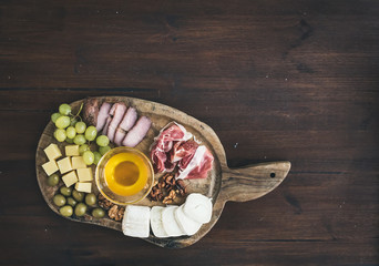 Wine appetizers set: meat and cheese selection, honey, grapes, w