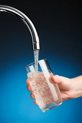 Rolgordijnen hand een glas water uit de filterkraan gieten © nikkytok