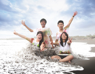 Obraz premium happy young people enjoying a beach in summer