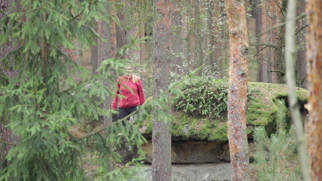 Ecstatic woman waving and dancing in the forest.