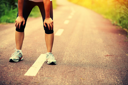 Tired Female Runner Taking A Rest After Running 