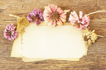 Paper sheets and flowers on wooden table
