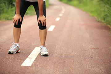 tired female runner taking a rest after running 