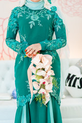 Unknown Malay Bride wearing green dress and holding a bouquet