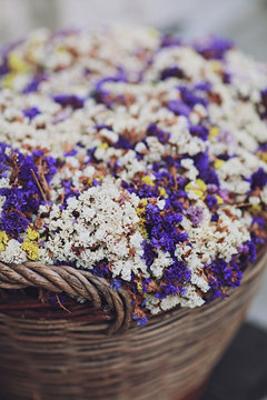 Violet and white dry flowers in the basket