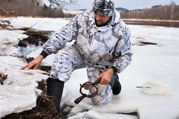 Obraz premium hunter setting a leghold trap for beaver
