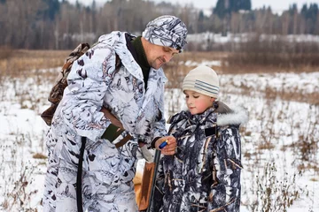 Photo sur Aluminium Chasser le chasseur montre à son fils comment charger l& 39 arme