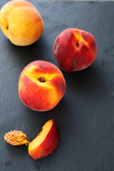 Fototapeta na wymiar ripe peaches on slate background
