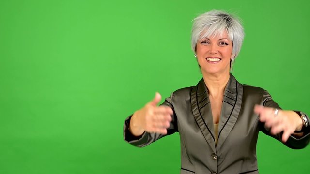 business middle aged woman welcomes - green screen - studio