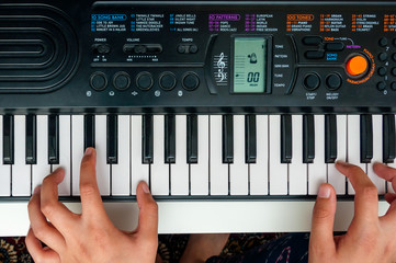 Child learning to play keyboard