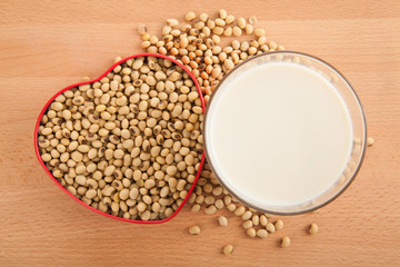Soy milk in glass with soybeans in heart shape box