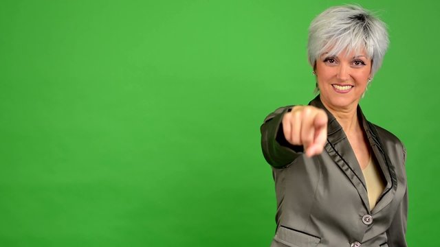 business woman points to the camera - green screen