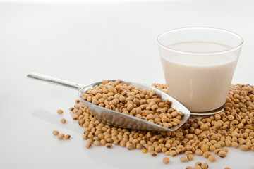 Soy milk in glass with soybeans and  transfer scoop