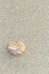 Heart shaped pebble on the sand beach