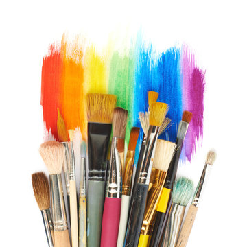 Pile of different brushes over the paint strokes