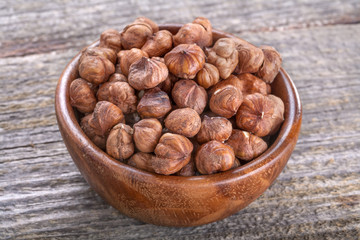 domestic hazelnuts in a wooden bowl on old rustic table