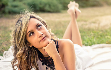 Naklejka premium Romantic girl thinking lying down outdoors