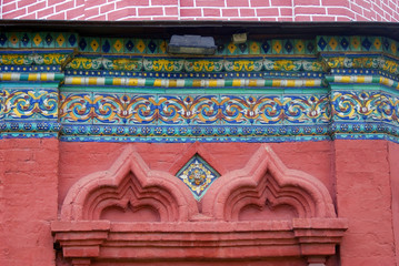 Colorful tails on red bricks wall. Epiphany church, Yaroslavl.