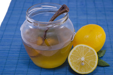 Jar of honey and lemons on blue background
