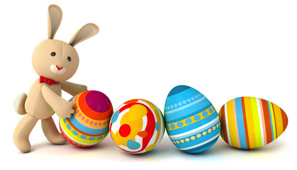Funny toy rabbit pushes painted Easter eggs