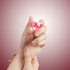 hand holding 3d red heart shape of diamond