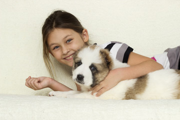 child, gently hugging a puppy