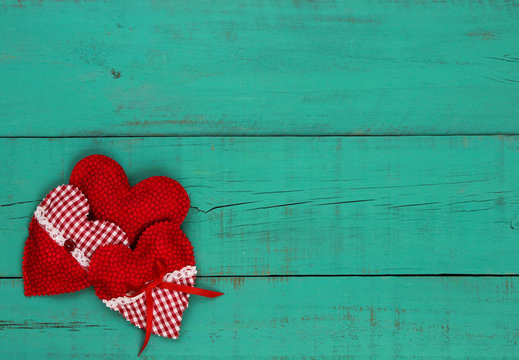 Red heart border on antique teal blue wooden background