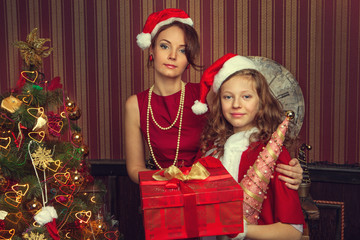 family wearing a hat of Santa Claus near new year tree