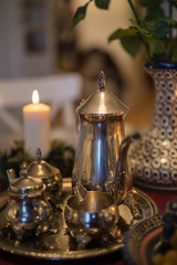 Fototapeta na wymiar Натюрморт с серебряной посудой, чайный сет, горящая свеча, романтический ужин